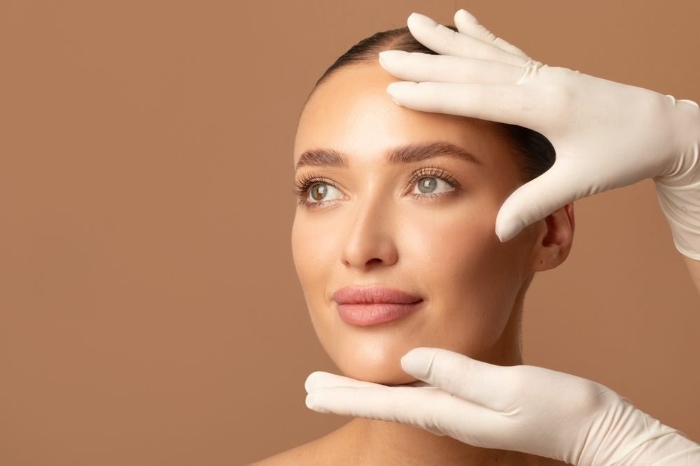 Évaluation de la peau : des mains gantées encadrent le visage d’une cliente